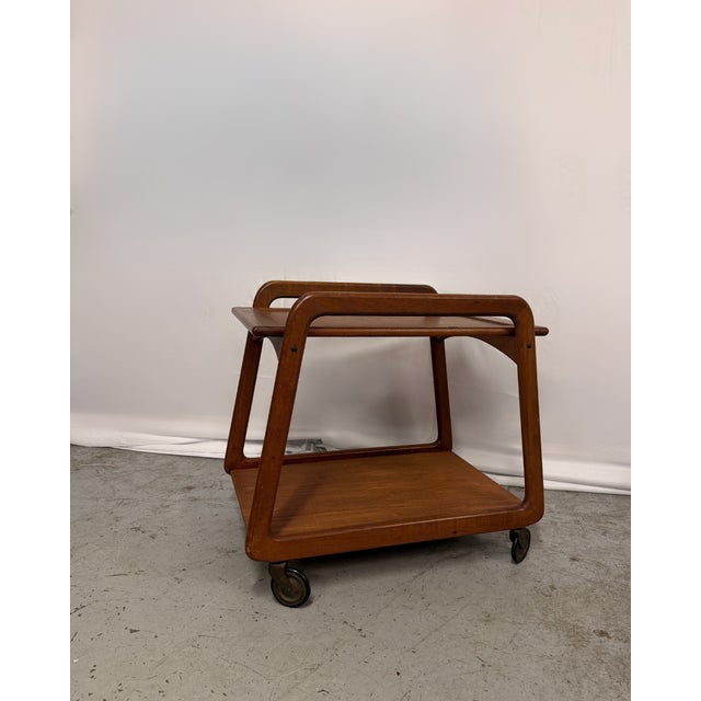Petite bar cart by Sika Møbler, crafted from solid teak, with an upper shelf that is detachable. Elegant design with...