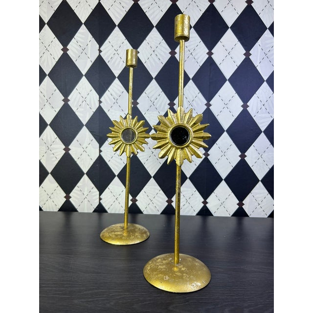 Pair of tall vintage gilt-metal candlesticks featuring dimensional sunburst medallions with inset round mirrors. Slender...