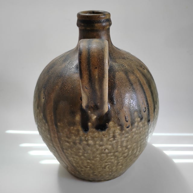 This item is a hand-thrown stoneware jug handcrafted by master potter Rodney Leftwich of Western North Carolina. It has a...