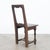 A wooden chair from Belgium, circa 1800. An upright shape with a striking open-framed backrest and a square paneled seat...