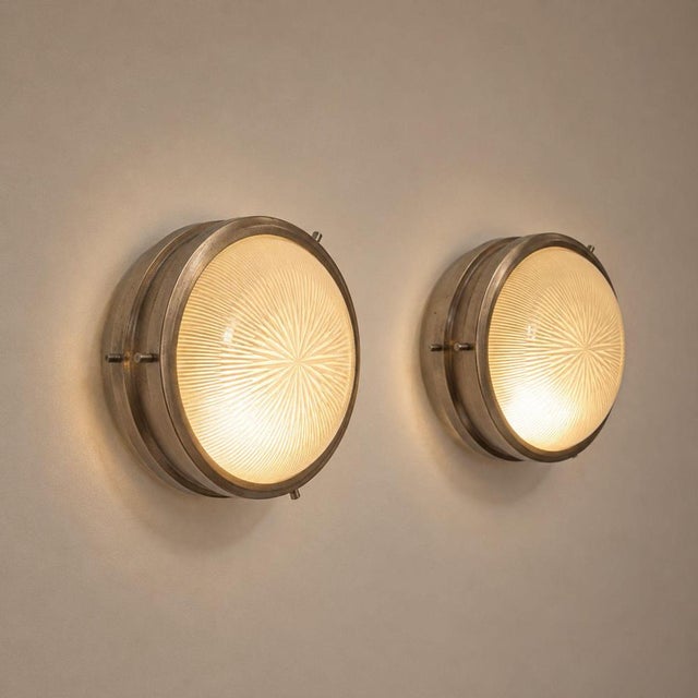 A pair of Sigma wall lamps designed by Sergio Mazza for Artemide in 1960, made of nickel-plated brass and molded glass....