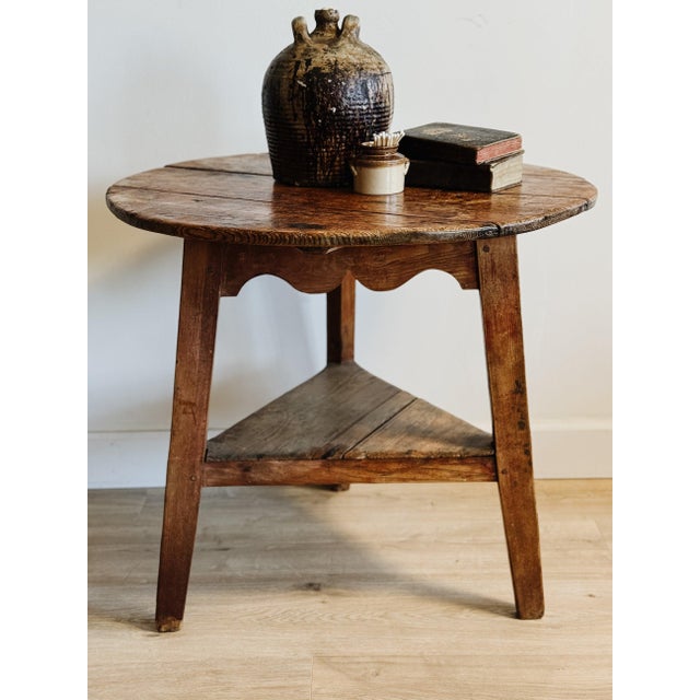 An English Georgian pine cricket table dating to the late 18th century, its generous round top showing a beautifully worn...