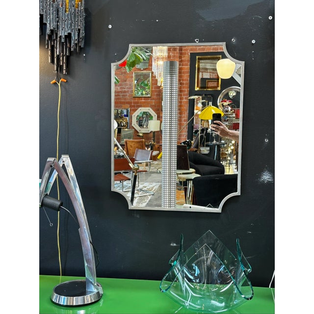 Vintage Italian sculptural wall mirror with a chrome frame and original patina.