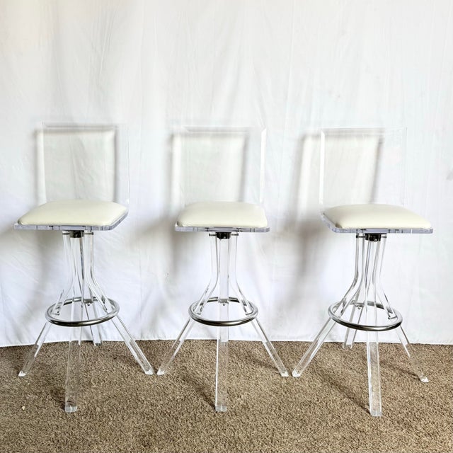 Elevate your interior with this stunning trio of postmodern Lucite bar stools. Featuring sculptural clear acrylic frames...
