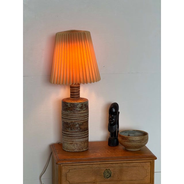 Danish table lamp in partially glazed stoneware, attributed to Tue Poulsen 1960s–1970s. The base is a bottle form, with a...