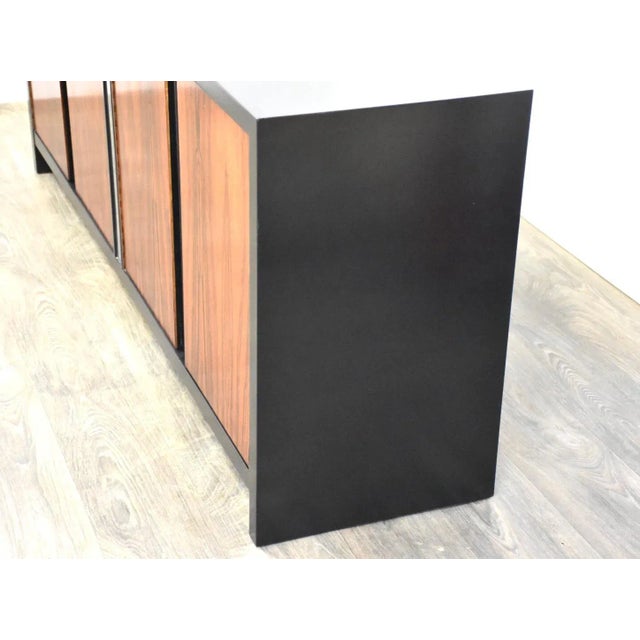 A Milo Baughman style black case dresser with rosewood doors and chrome accents. 75” wide. 18” deep. 30.25” tall. This...