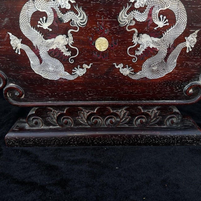 A vintage Chinese table screen (pingfeng) of rectangular form with cloud-scrolled ruyi corners, raised on a matching...