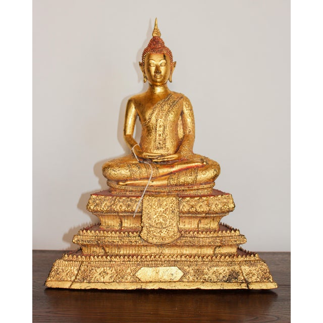 This bronze Buddha from Ayutthaya is seated on a throne with three steps and a royal peaked base, wearing royal regalia....