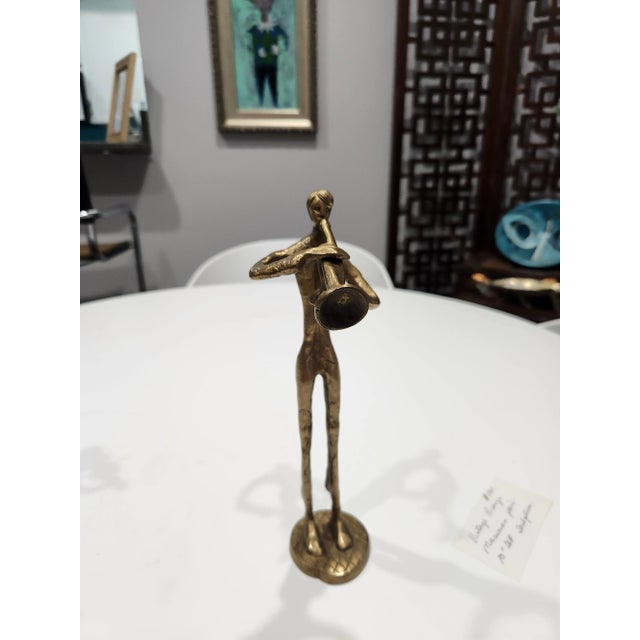 Pair of Bronze sculptures depicting musicians, one holding g a violin and the other holding a trumpet.