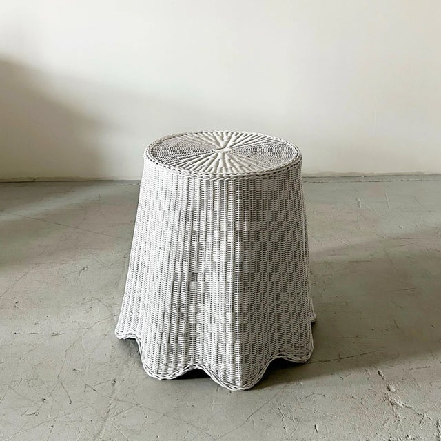 A trompe l’oeil “Ghost” white wicker side table featuring a draped silhouette. It's a delightful and elegant design....