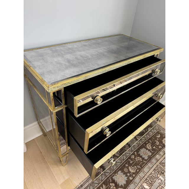 Elegant Horchow three-drawer chest featuring antiqued mirrored panels, distressed gold-tone trim, decorative round pulls,...