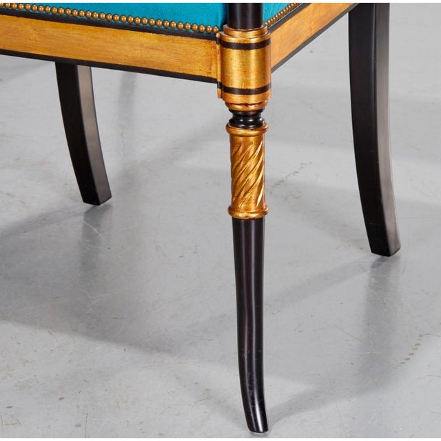 20th c., with scroll back, channeled arms ending in scrolls, raised on slender sabre legs, the padded back and seat...