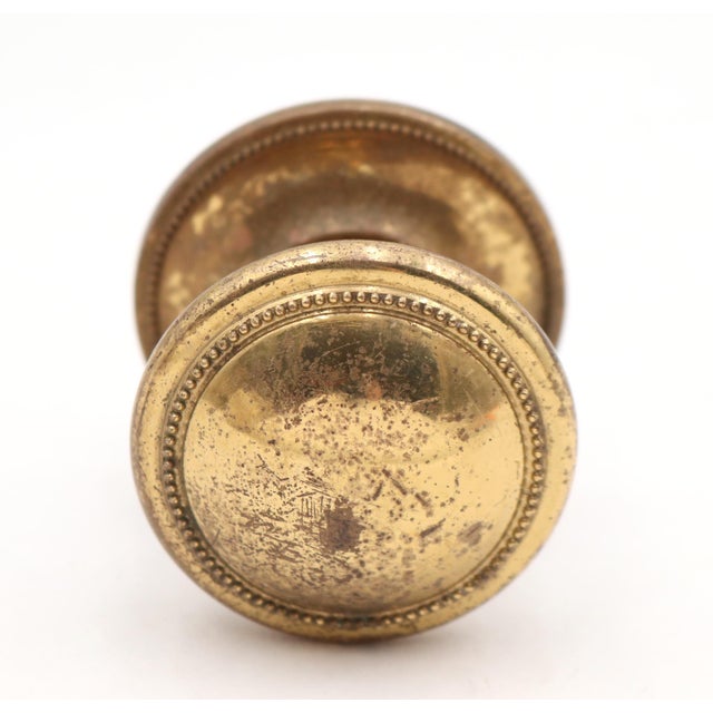 Reclaimed dummy door knob set made of polished brass with a beaded design. The rosette is stamped 'Made in Italy'. Priced...