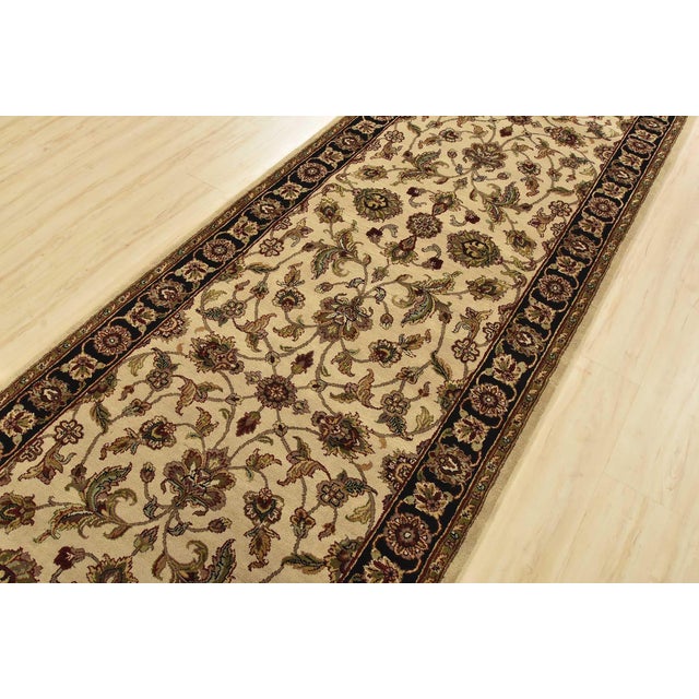 A traditional Agra runner hand-knotted with an all-wool pile on a cotton foundation. This finely woven oriental rug...