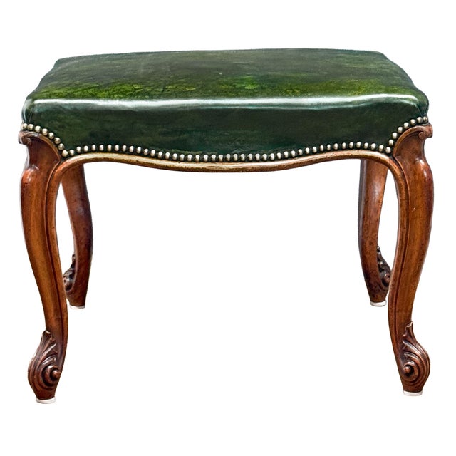 A fine French ottoman or stool featuring a beautiful upholstered seat of emerald green leather, with brass nail-head trim...