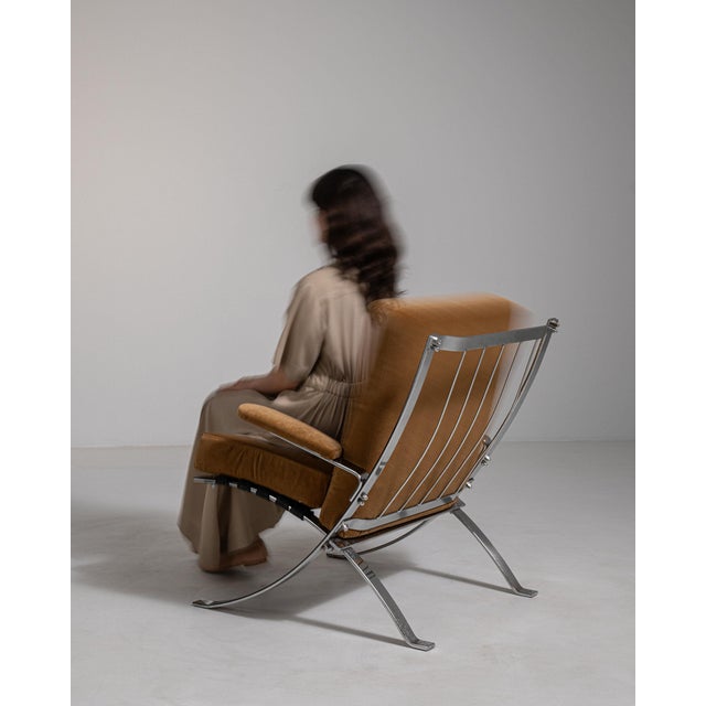 Chrome-frame lounge chair in Warm Burnt Orange. Its warm burnt orange finish sets off tubular chrome frame, burnt orange...