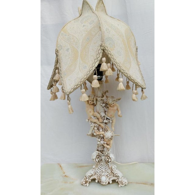 Reproduction made of resin circa 1980 Very striking desing with angels. The pedestal size 7,8'x7,8'x17,7' The lamp...