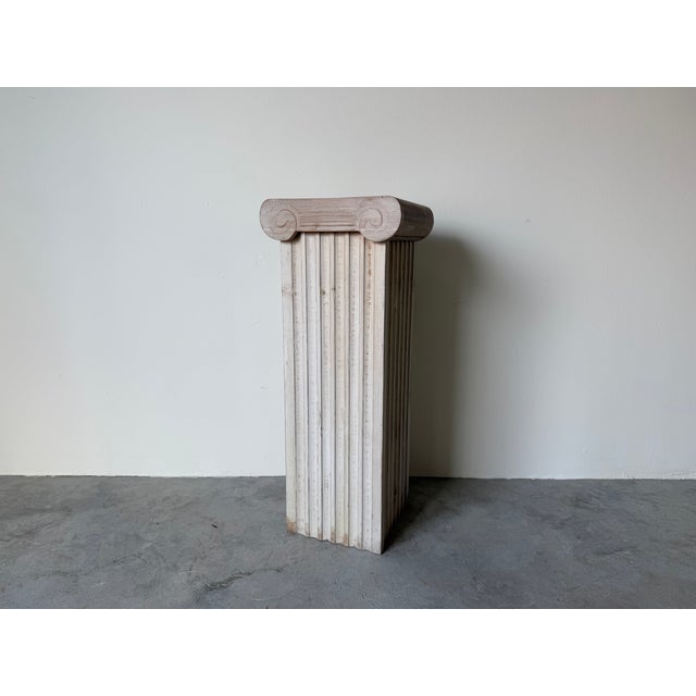 Elegant vintage Hollywood Regency pedestal featuring a classic neoclassical column silhouette with vertical fluted...