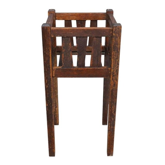 This antique Mission style plant stand, crafted from oak, features a classic slatted design characteristic of the early...