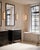 The Blaine Bronze Bath Wall Sconce has a tubular design, with a milky glass tube set into the metal rings in a polished...