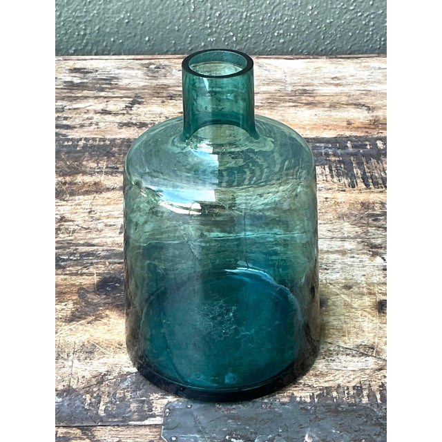 This vintage small teal glass vase embodies the refined simplicity and functional elegance associated with mid-20th-...