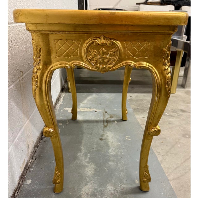 A vintage reproduction Louis XV style giltwood side table with cabriole legs with carved scroll feet and carved rococo...