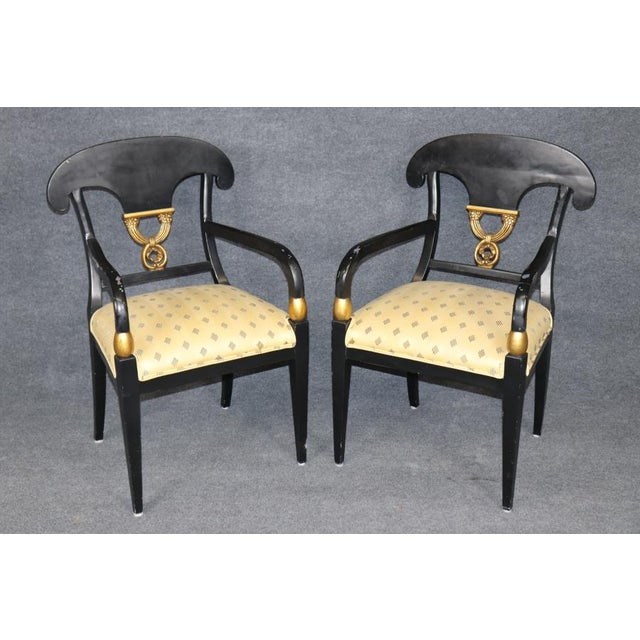 An elegant and highly decorative set of four Neoclassical Empire-style armchairs, distinguished by their sophisticated...