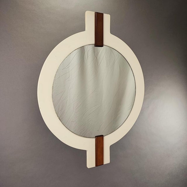 Wall mirror with a post-modern design, vintage from the 70s. Structure in ivory-coloured lacquered walnut. Design period...