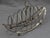 Sterling silver toast rack, London, 1797 by James Kidder. Boat form raised on short ball and claw feet with gadrooned...