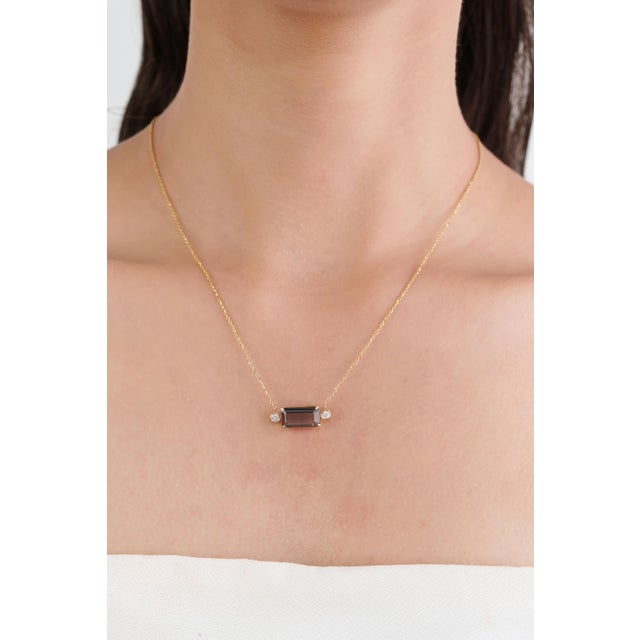 This handmade pendant necklace features a 3.26 carat natural green tourmaline, set in 14K yellow gold. The center stone...