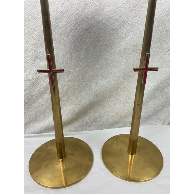 Impressive 19 inch tall brass altar candlesticks from the mid-century era with enameled crosses attached at mid shaft....