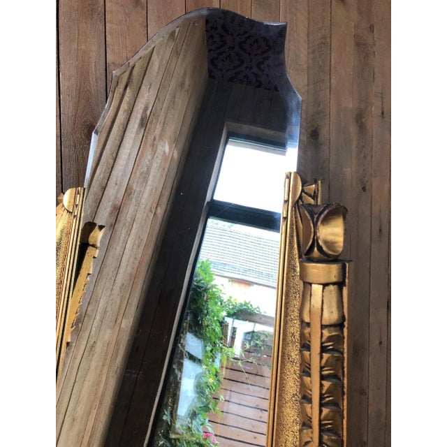 The mirror is bevelled on the top, has wheels, can move. The tilting is done with the help of small chains behind the mirror.