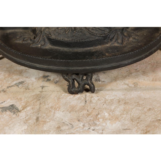 An English iron umbrella stand from the 20th century depicting a dog obediently sitting in front of a tree. Embrace the...