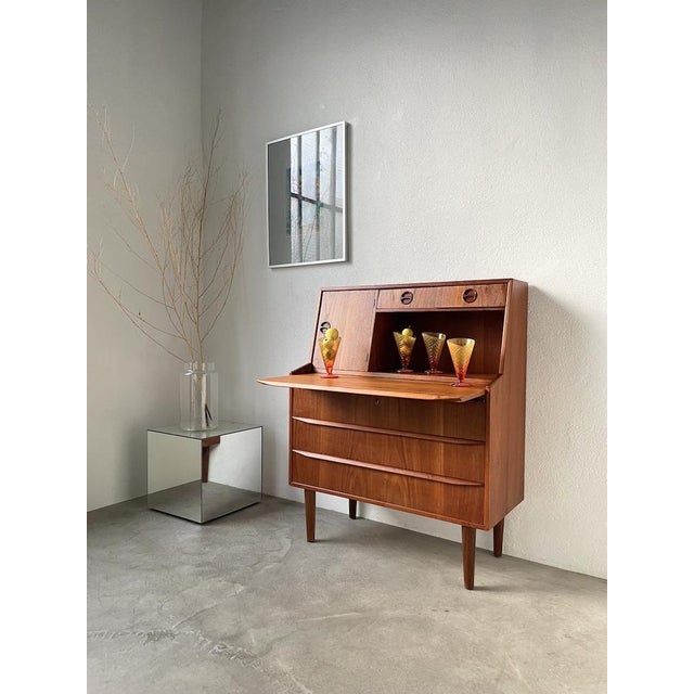 Old Danish teak secretary desk from the 60s. This storage unit is ideal for interiors with limited spaces. It can easily...