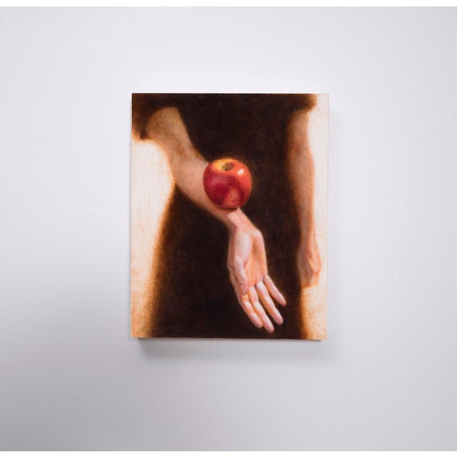 This artwork depicts a serene composition featuring a hand gracefully extended, cradling a vibrant red apple that rests...
