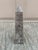 A beautifully proportioned marble obelisk in richly veined shades of brown, cream, and grey. The sculptural silhouette and...