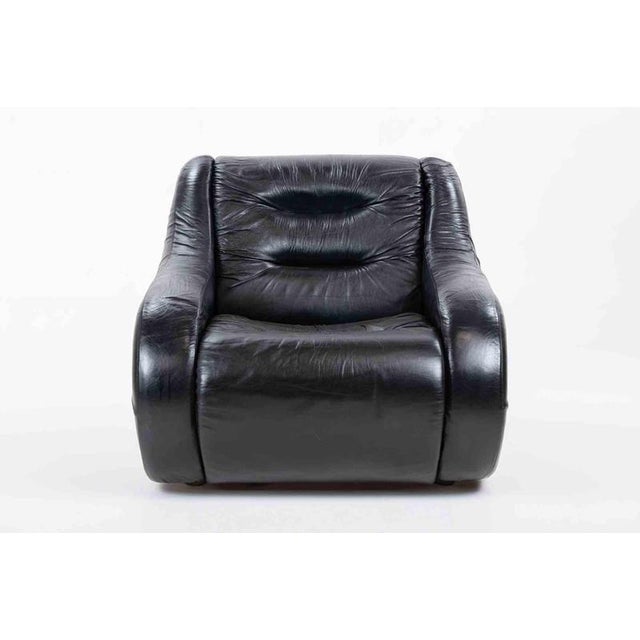 A generously proportioned lounge armchair featuring an enveloping, organically contoured silhouette characteristic of...