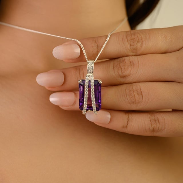 This 925 sterling silver pendant features a stunning 18x13 mm octagon-cut amethyst weighing 16.8 carats, radiating a rich...