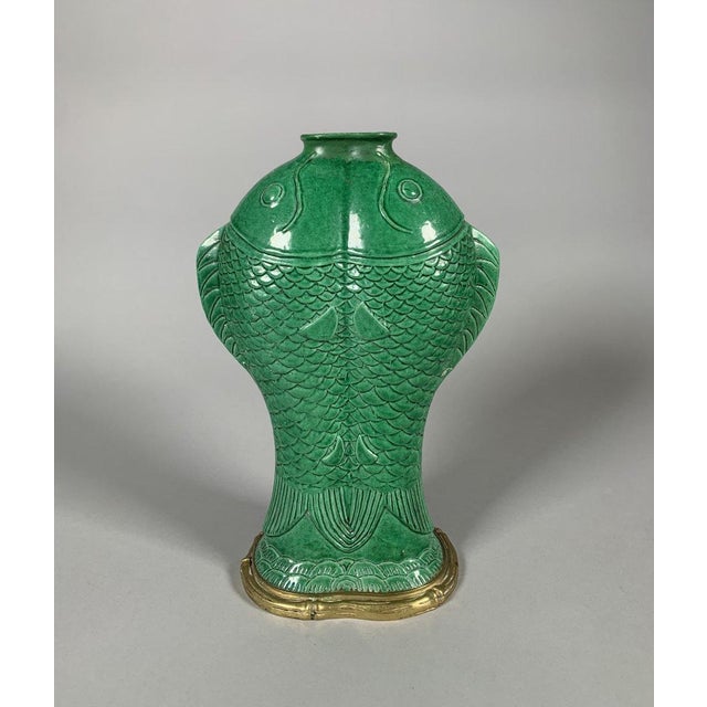 Kangxi period porcelain vase (1662-1722) . Monochrome green glaze. The design features "carps joined together." The gilt...