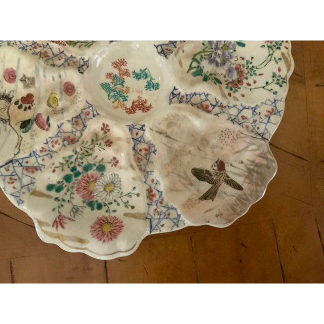 Rare oyster plates featuring hand painted floral and bird motifs across scalloped compartments.