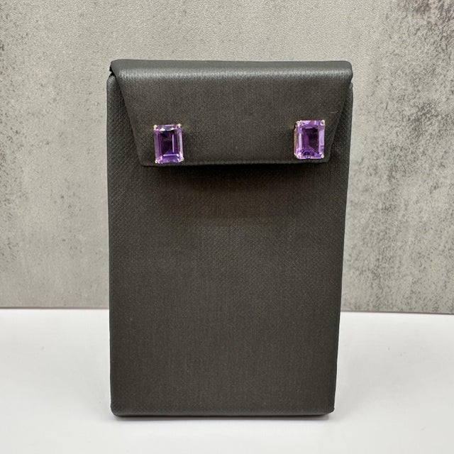 These amethyst stud earrings are crafted in 14kt yellow gold and feature two vibrant 8x6mm emerald cut amethysts. The...