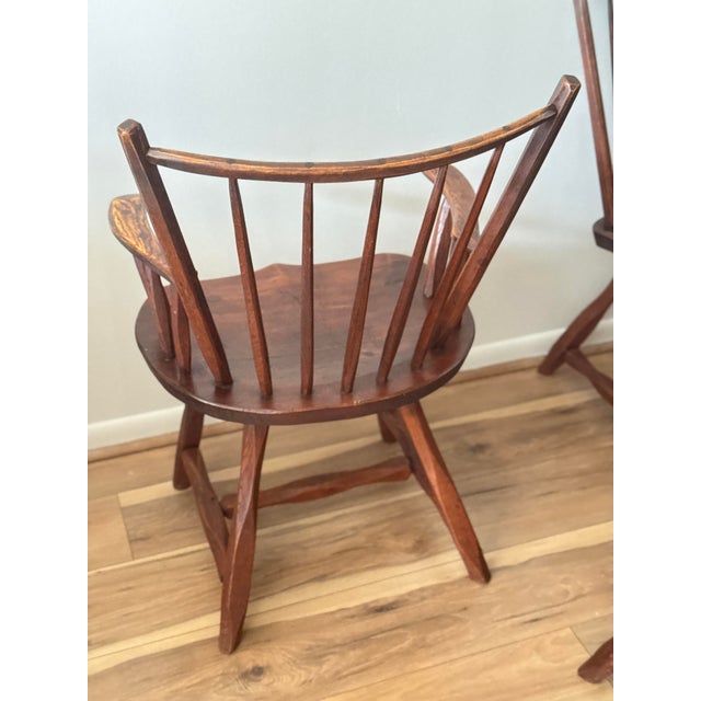 Set of four dining chairs, late 20th century. Solid wood construction with sculpted plank seats and turned spindle backs....