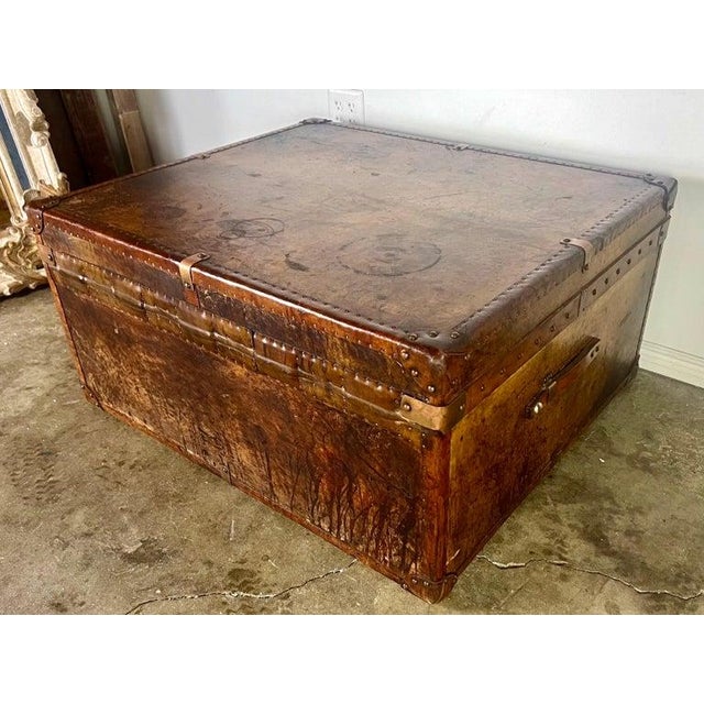 A 19th Century steamer trunk that can be used as a coffee table, featuring original brass and copper hardware, with...