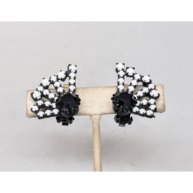 1960s japanned prong set round single faux-onyx with many prong set white round rhinestones fanning out from it clip back...