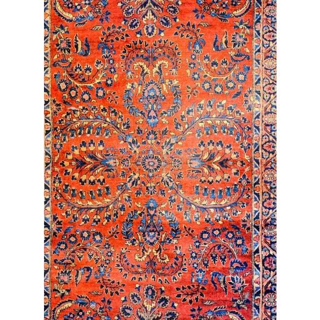 A beautiful early 20th century Persian Sarouk rug with a fantastic mirrored floral and vine pattern, expertly rendered, in...