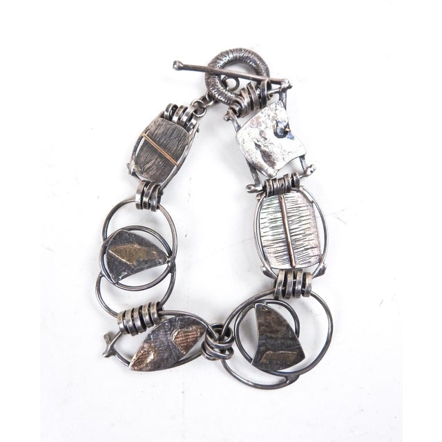 Late 20th century sterling silver and gold foil fused link bracelet. Abstract layered shapes and spirals. Marked faintly...