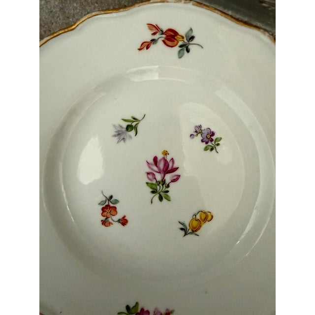 This antique German Meissen porcelain small bread & butter or dessert plate features hand-painted scattered flowers and...
