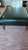 traditional custom made ottoman with medium stained turned lags and brass casters. upholstery is a dark green pleather...
