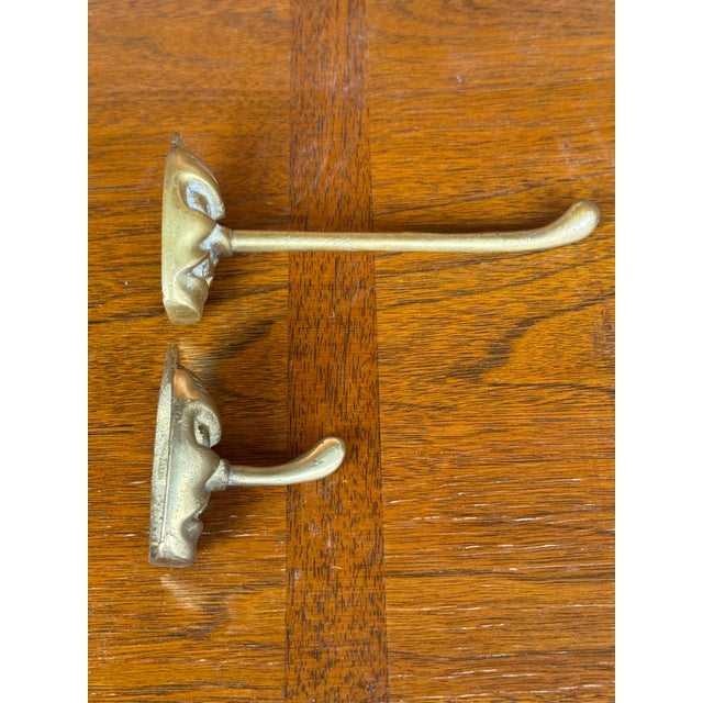 Bring whimsy, character, and a touch of folklore to your walls with this set of two vintage brass wall hooks, depicting...