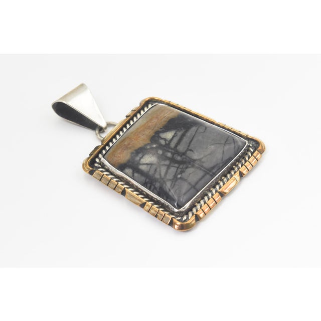 Stunning pendant by Zuni silversmith artist Sensa Eustace. She has combined sterling silver gold-tone detailing and placed...